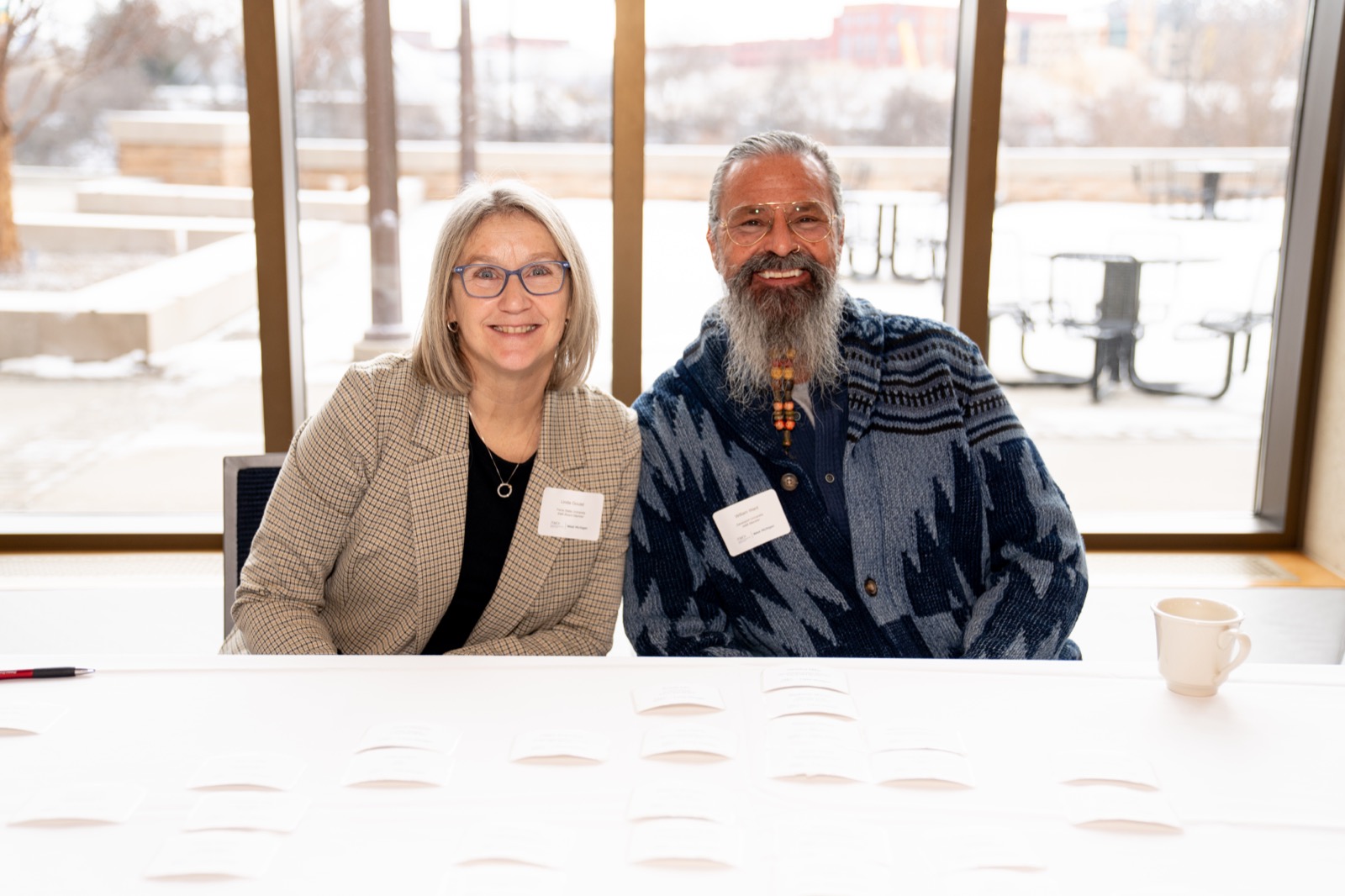 Two smiling members seated together at a chapter event