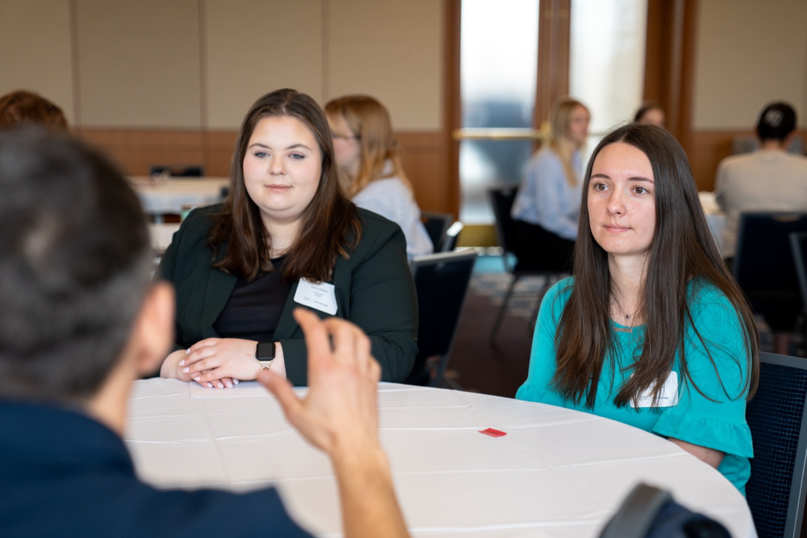Two students listening to a mentor at the Marketers in the Making event