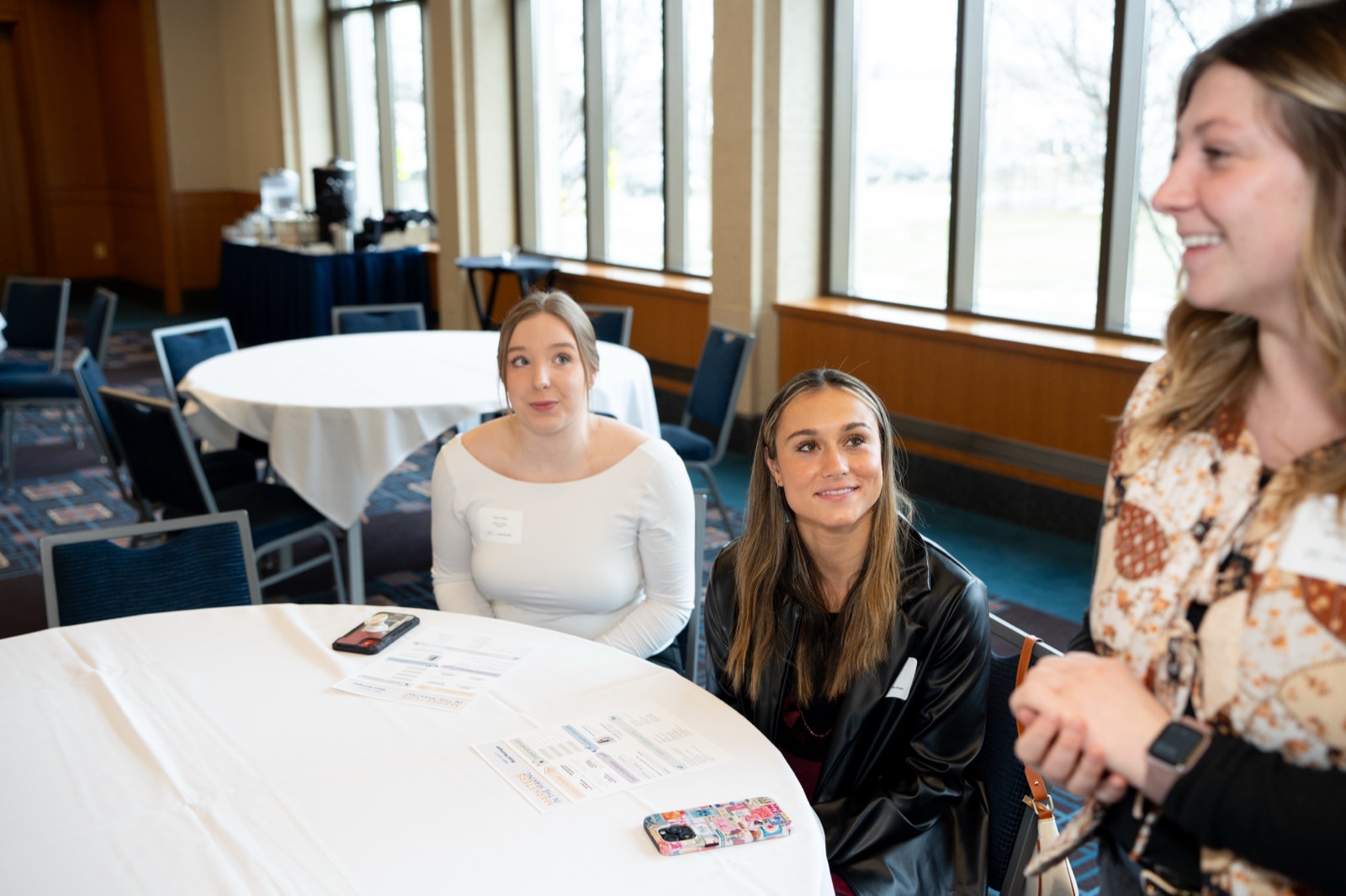 Members in conversation at a round table during a chapter event