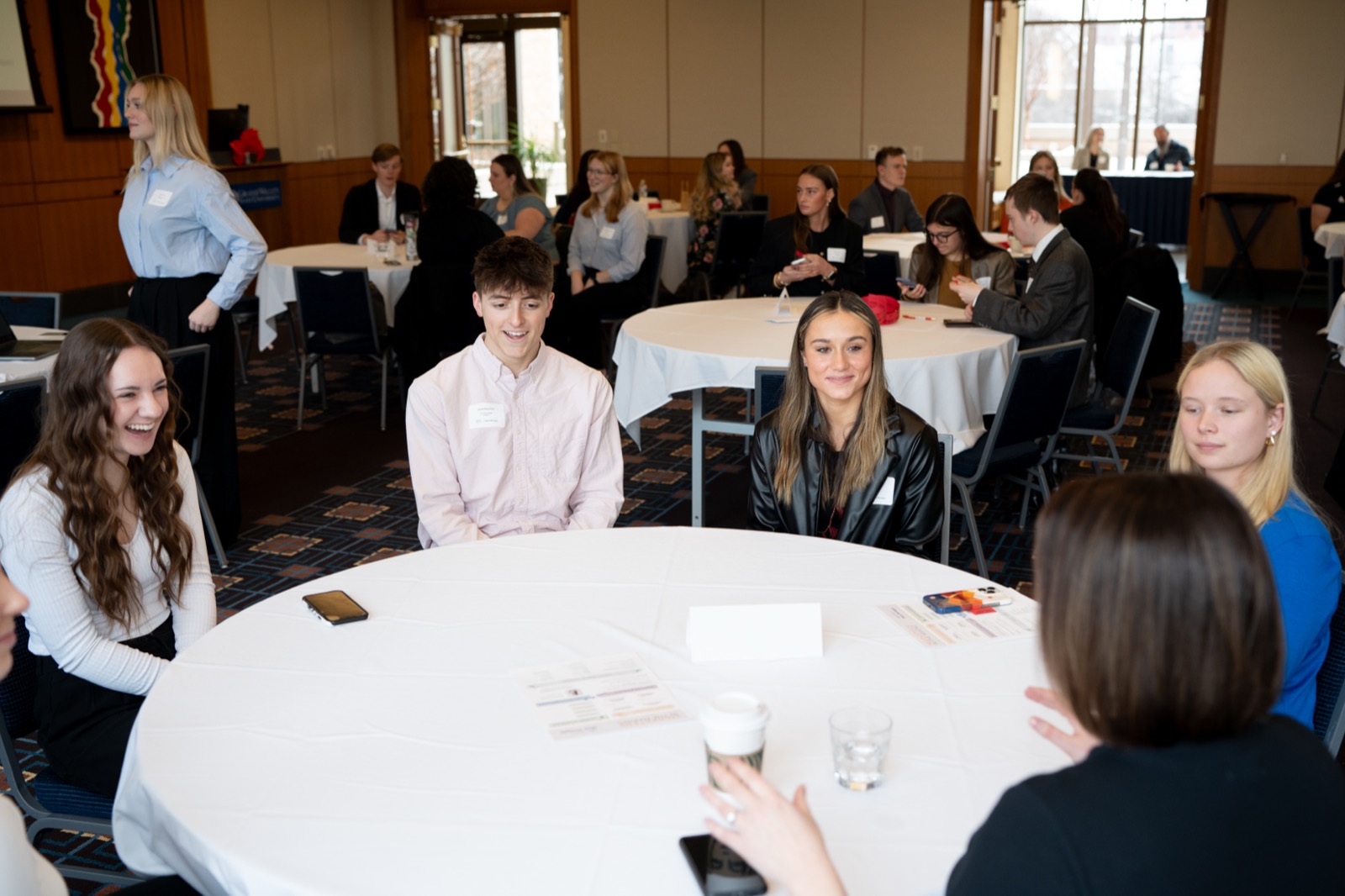 Attendees laughing together around a table at a chapter event