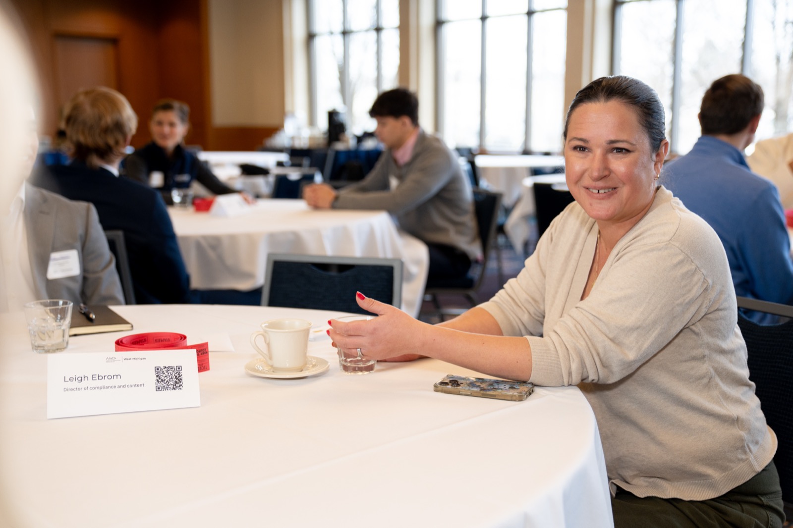 A smiling attendee seated at an event table