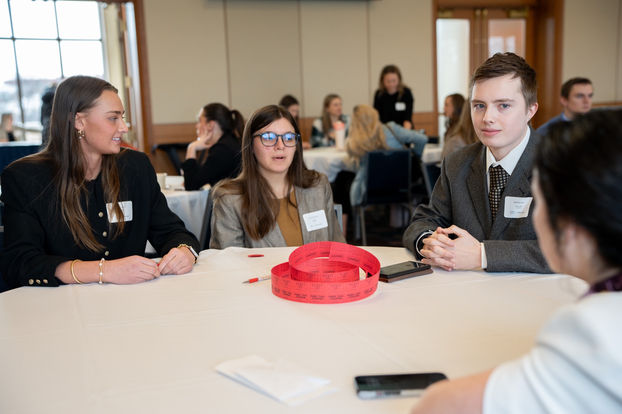 Three students in conversation at a round table during the student networking event