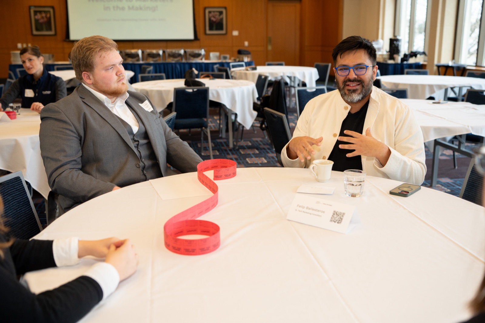 Two attendees in conversation at a round table